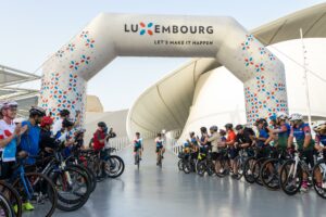 Andy Schleck (R), Tour de France winner, and Georges Engel (L), Minister of Sports in Luxembourg, ride out of the Luxembourg Pavilion during Ride The World